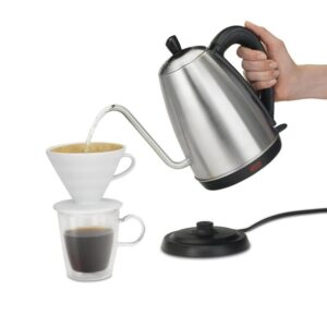 A Hamilton electric kettle pouring hot water into instant coffee maker