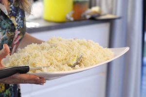 Woman carrying large plate of rice